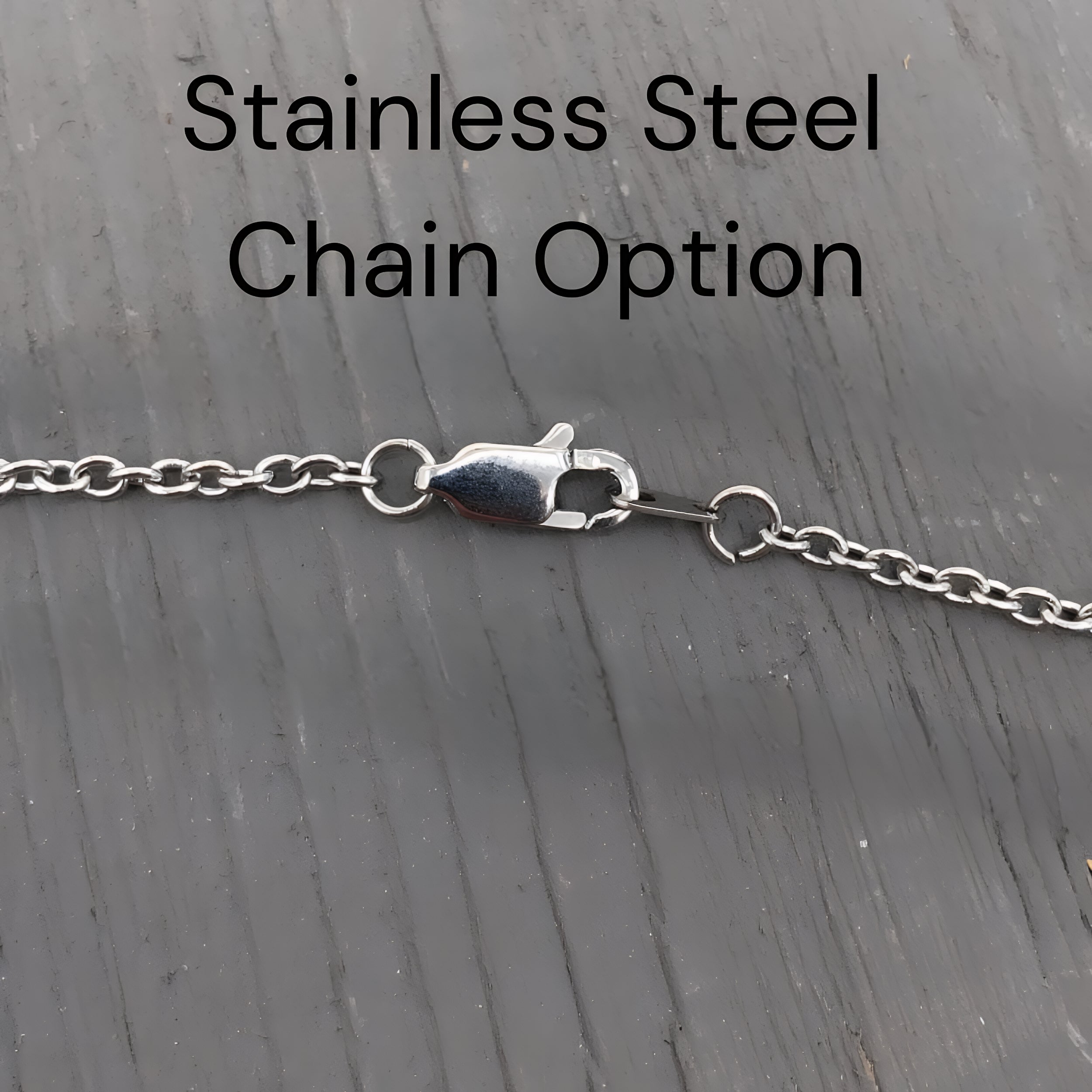 a close-up view of a stainless steel chain with a clasp, placed on a wooden surface.