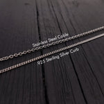 three different types of silver chains laid out on a wooden surface.
