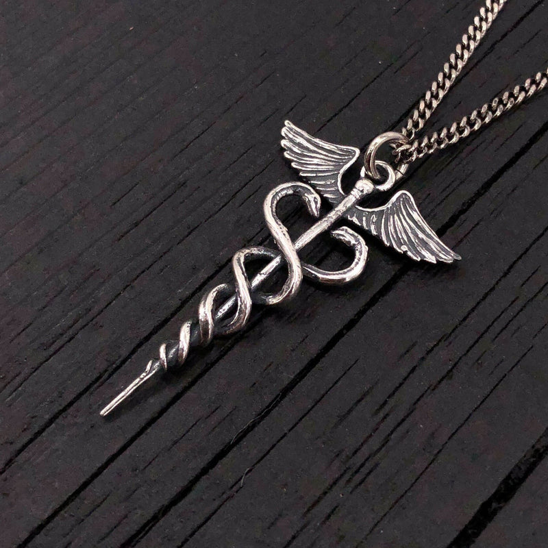 This beautifully detailed caduceus is cast in sterling silver, oxidized in recesses to enhance the fines detail of this 1.5&quot; long pendant.