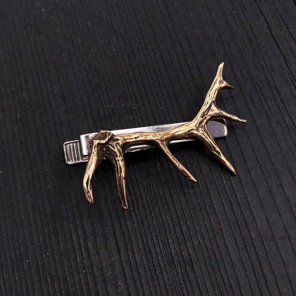 This defined 3D elk antler is cast in solid bronze, oxidized to enhance the fine details of this beautifully sculpted little carving. The 2-1/8&quot;long high relief antler is mounted on a solid nickel plated tie clasp with an overall width 2&quot;.